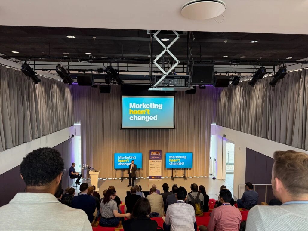 Mautic World Conference in London: a packed room facing the stage, slides reading Marketing hasn't changed