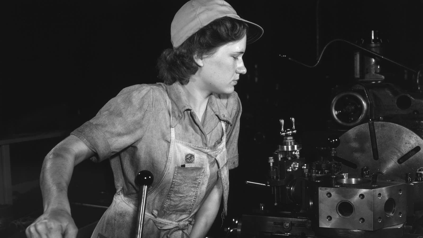 A machinist works a turret lathe in an aircraft factory, 1942